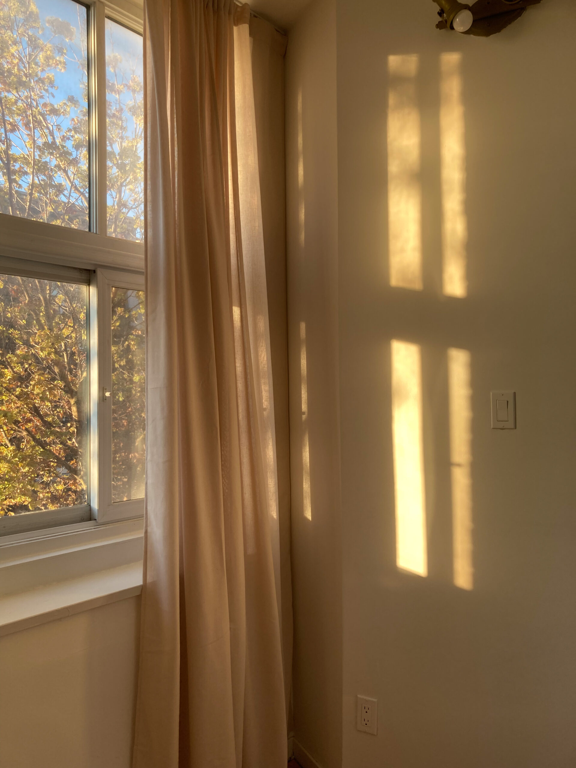 Reflets de la lumière sur le mur d'un appartement en fin de journée